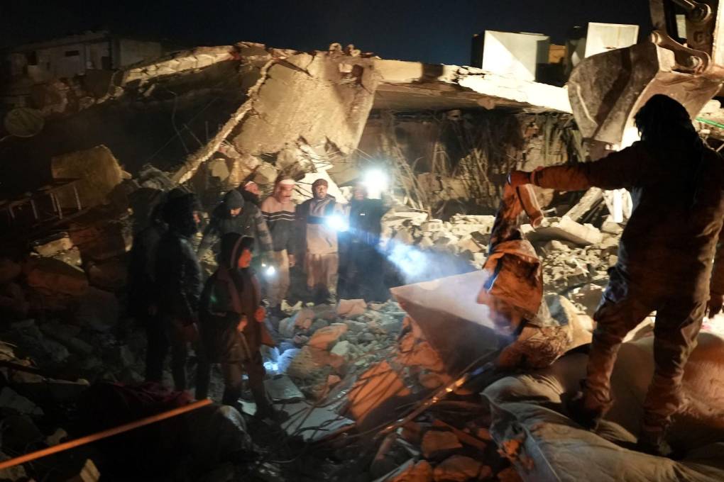 Sirios buscan entre los escombros de una casa.