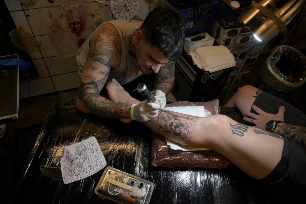Tebi Cobra Vucinovich trabaja en un tatuaje sobre el logro argetino en el torneo mundial de fútbol en su taller Ds Tattoo en Buenos Aires.