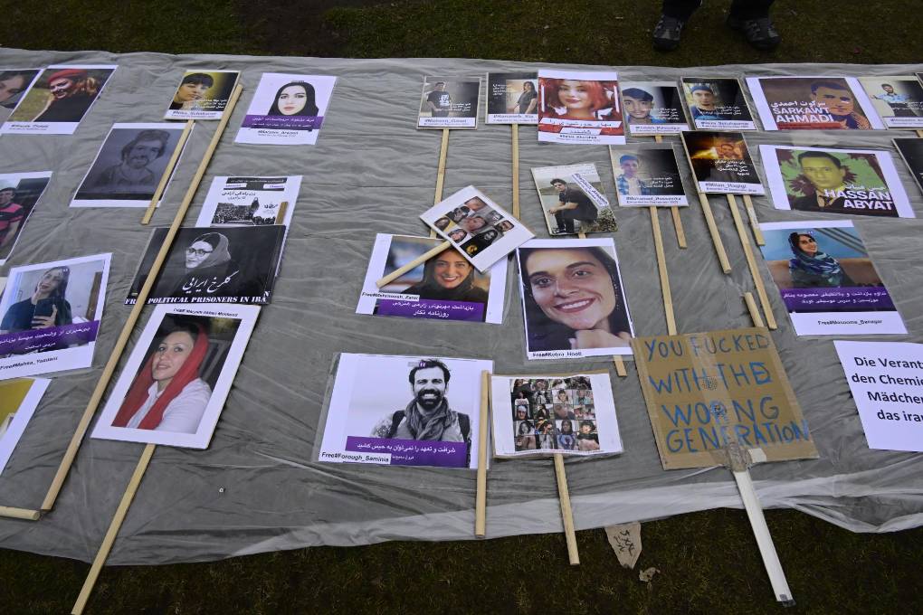 Portraits of missing and victims of the Iranian regime are seen on the ground in front of the German lower house of parliament (Bundestag), on the occasion of the International Women's Day, on March 8, 2023. (Photo by John MACDOUGALL / AFP)