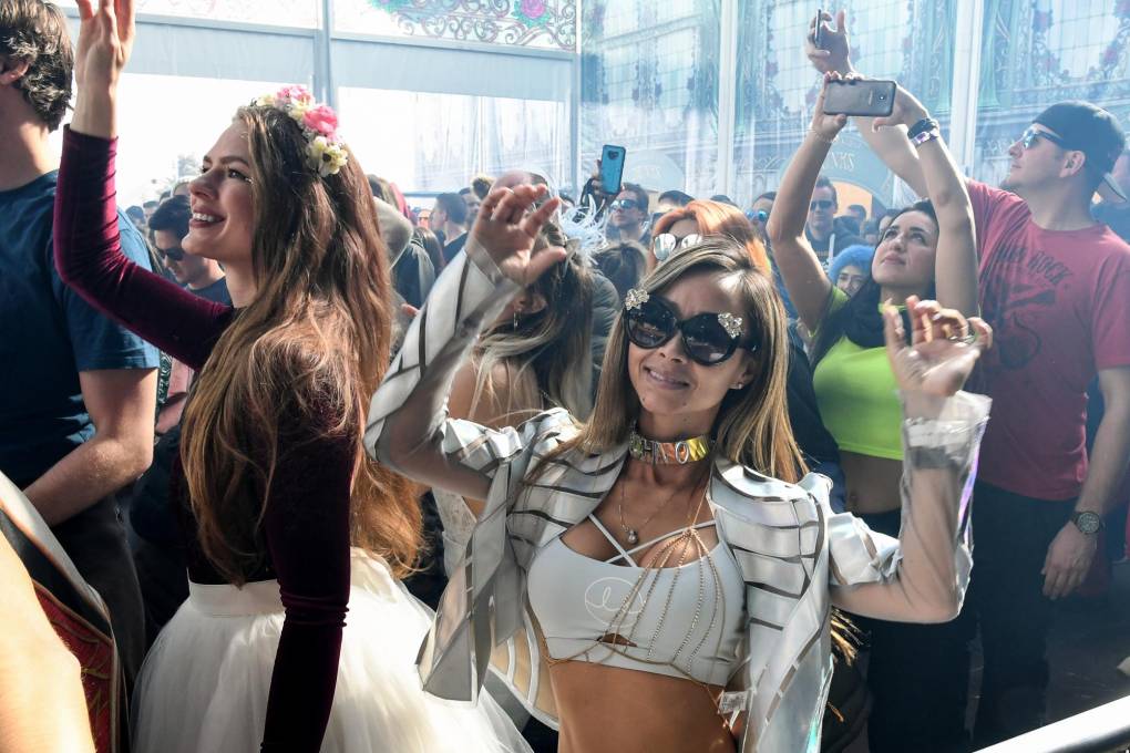 Revelers dance as a DJ perfors during the first winter edition of the Tomorrowland electronic music festival, in l'Alpe d'Huez, eastern France, on March 13, 2019. (Photo by JEAN-PIERRE CLATOT / AFP)