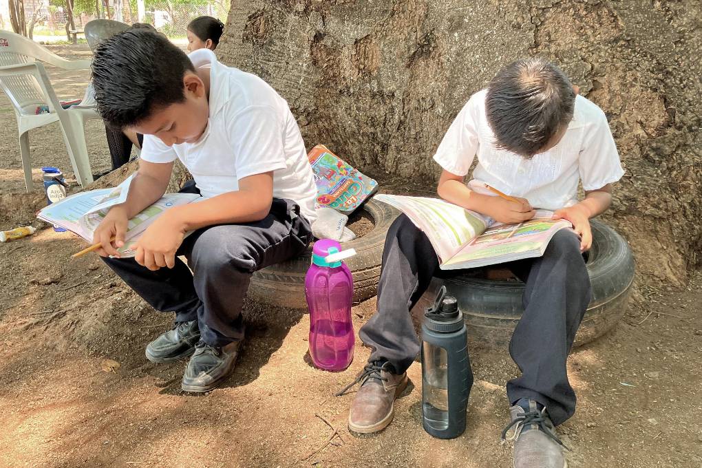 Alumnos tomas clases en el patio de una primaria debido al intenso calor.