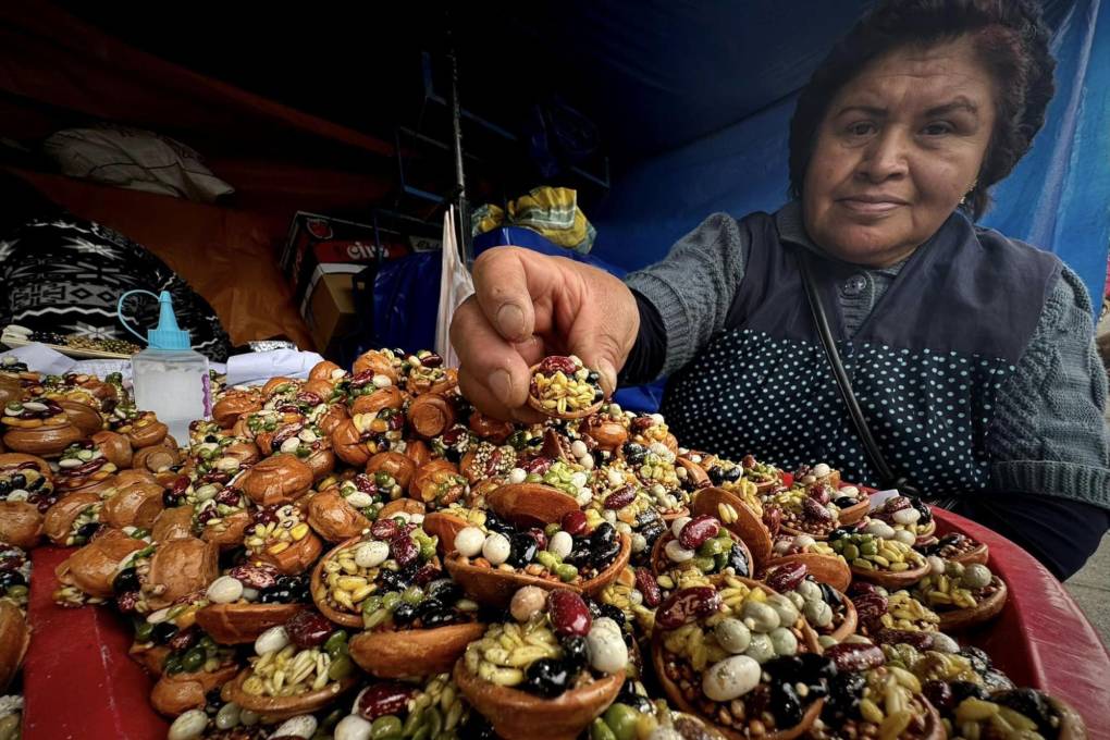 Una artesana muestra una bandeja con alimentos en miniatura. 
