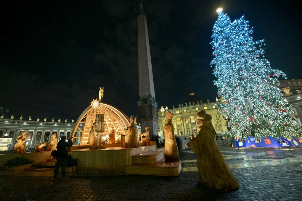Árbol de Navidad iluminado y un pesebre en la Plaza de San Pedro en el Vaticano.