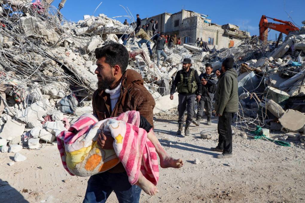 Un hombre lleva el cuerpo de un niño que sacó de los escombros en la ciudad de Harim, en la provincia noroccidental de Idlib en Siria.
