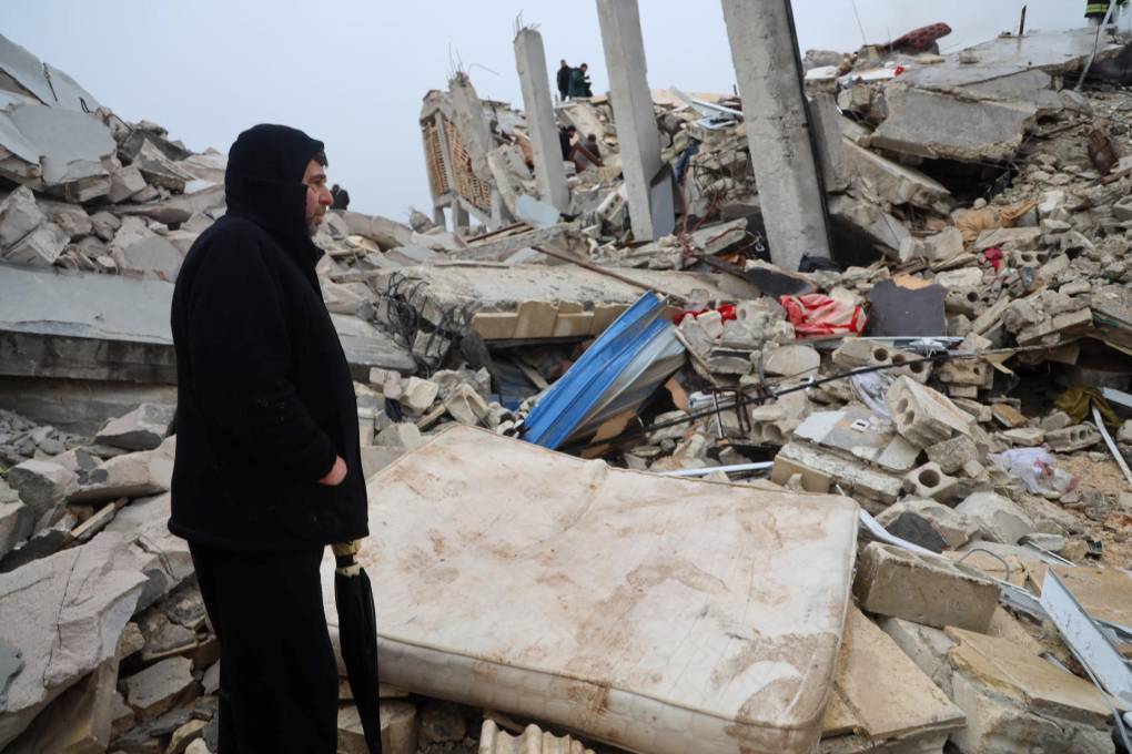 Un hombre se para junto a los escombros de un edificio luego de un terremoto en la ciudad de Sarmada en el campo de la provincia noroccidental de Siria Idlib, temprano el 6 de febrero de 2023.