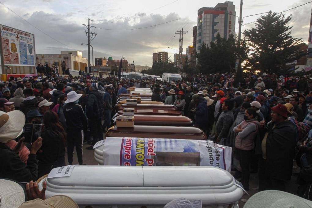 Familiares de las víctimas de los enfrentamientos con la policía peruana esperan con ataúdes vacíos frente a la morgue