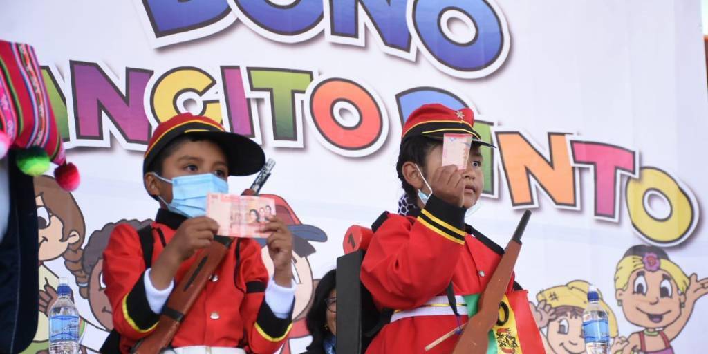 Niños muestran los 200 bolivianos del Bono Juancito Pinto.