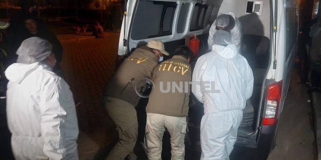 Efectivos de la Felcv introducen el cuerpo de la víctima en un vehículo para llevarlo a la morgue.
