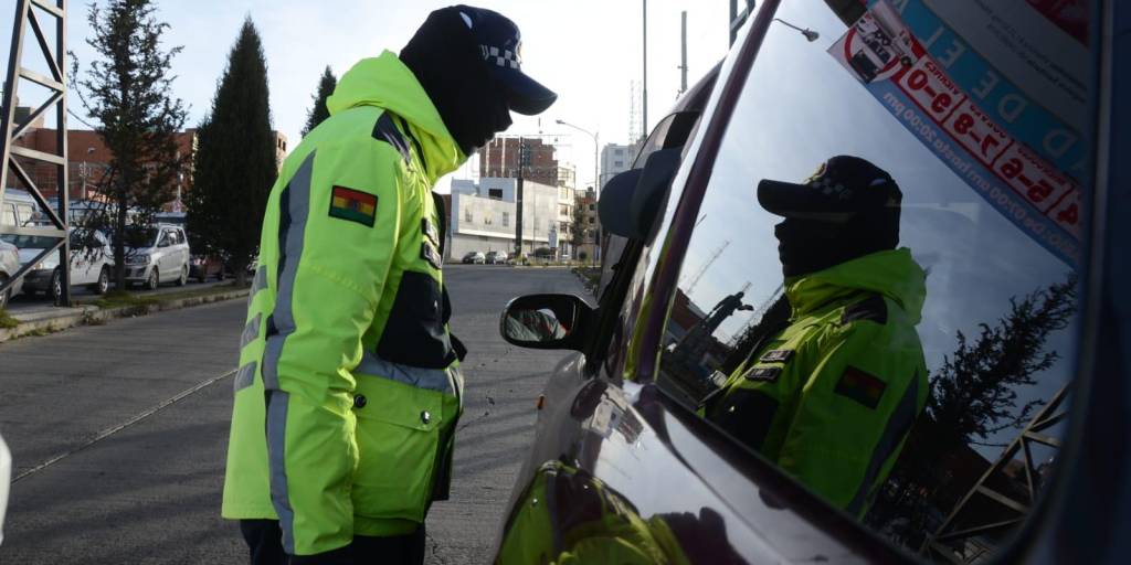 Un guardia edil controla la circulación de un vehículo en El Alto.