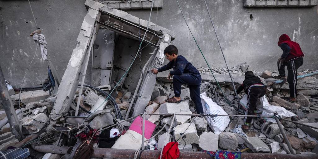 Niños caminan sobre los escombros dejados por la destrucción de los ataques