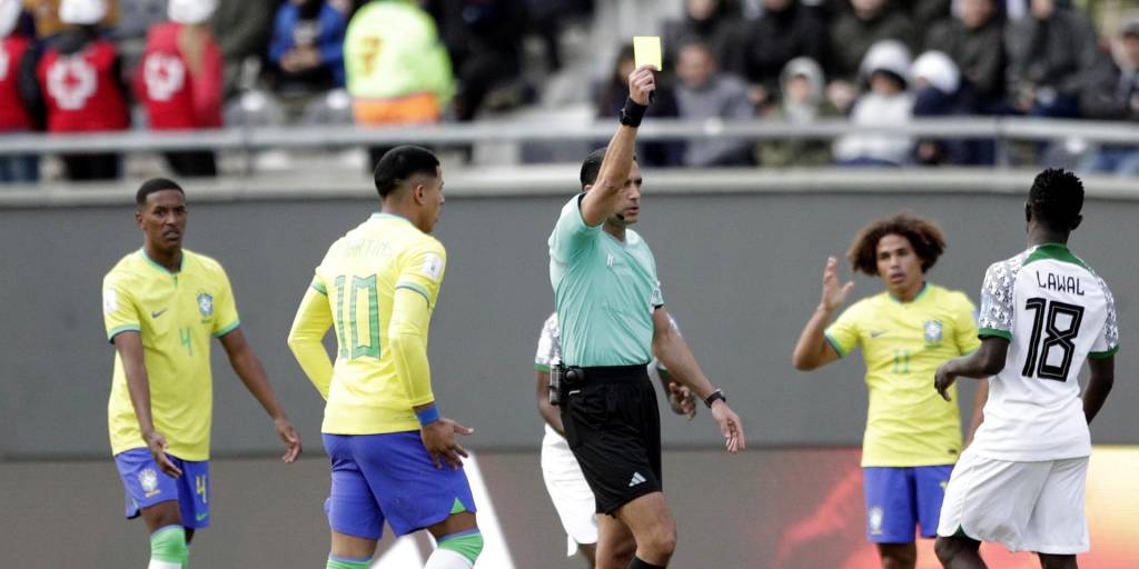 Samson Lawal (d) de Nigeria recibe tarjeta amarilla de parte del árbitro holandés Sedar Gozubuyuk