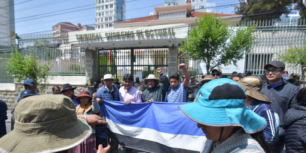 Un grupo de evistas posa frente a las puertas del TSE, en La Paz.