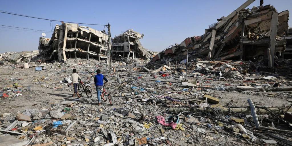 Los palestinos inspeccionan los daños a sus hogares y buscan pertenencias a su regreso entre los escombros de los edificios destruidos en Al-Zahra, en las afueras del sur de la ciudad de Gaza