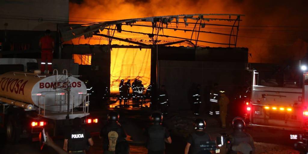 Bomberos atacan el fuego en la fábrica de plásticos.