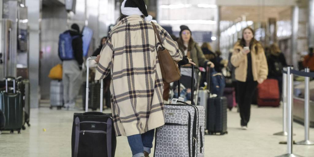 Viajeros de vacaciones abarrotan el aeropuerto metropolitano de Detroit.