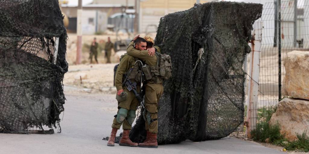 Los soldados israelíes se consuelan frente a la base militar del Monte Harif, cerca de la ciudad de Mitzpe Ramon, en el desierto de Negev, tras la muerte de militares en esa zona.