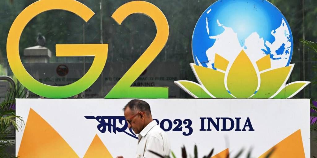 Un peatón pasa junto al logotipo de la cumbre del G20 instalado a lo largo de una calle de Nueva Delhi.
