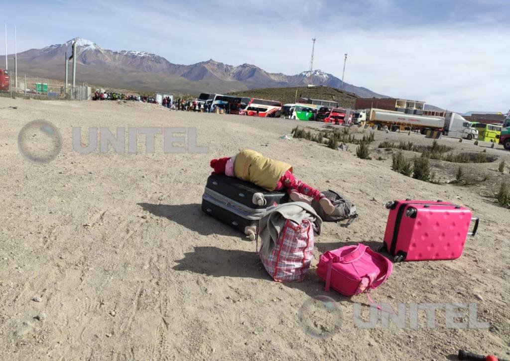 Una niña duerme sobre una maleta en la frontera entre Chile y Bolivia.