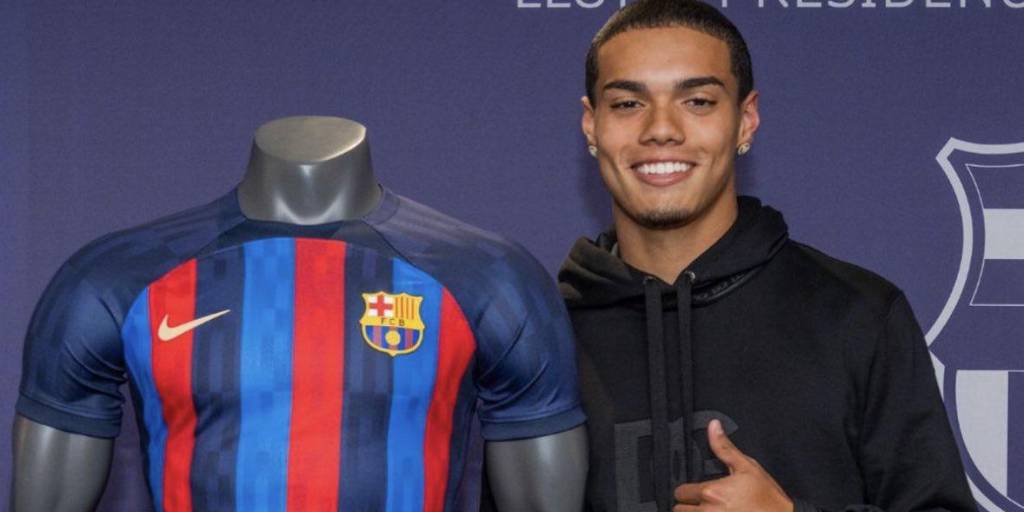 Mendes, el hijo de Ronaldinho, posa junto con la camiseta del Barça.