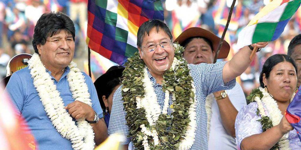 El presidente Luis Arce (d) ondea una bandera junto al exmandatario y líder del MAS, Evo Morales en Shinahota