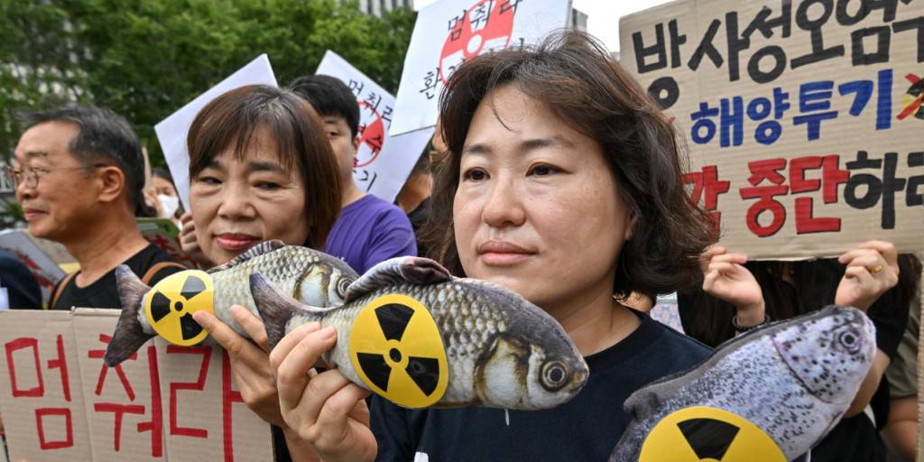 Activistas medioambientales surcoreanos sostienen muñecos de peces con signos radiactivos durante una manifestación contra el plan del gobierno japonés de liberar aguas residuales de la dañada planta nuclear Fukushima-Daiichi al Océano Pacífico.