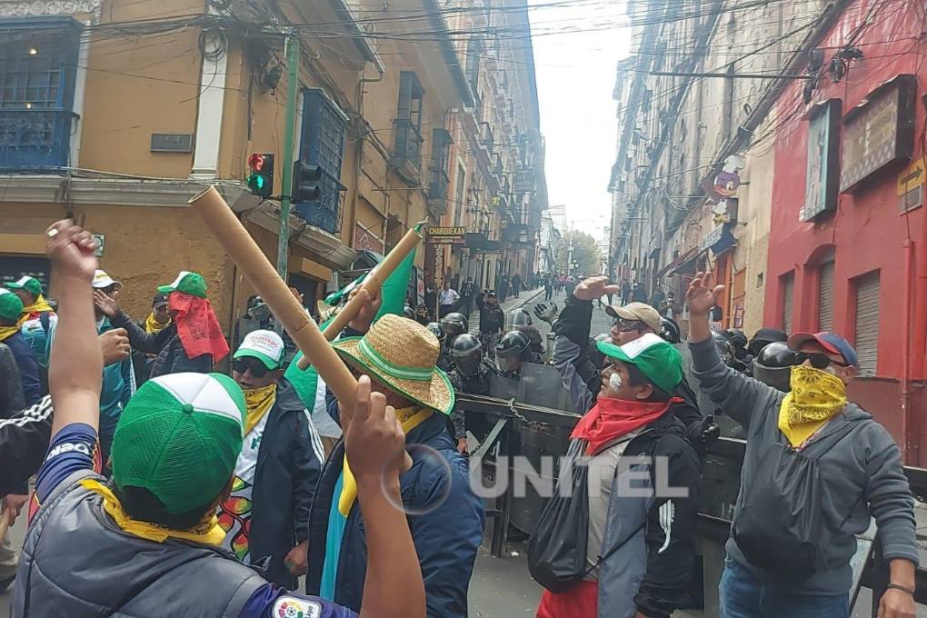 Un grupo de maestros protesta frente a los policías.