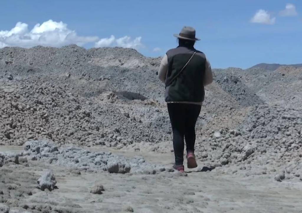 Una persona camina en medio de los desechos que deja la minería.