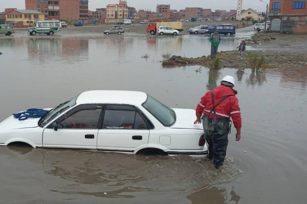 Un vehículo en medio de un pequeño lago formado por la lluvia