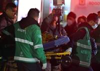 Uno de los niños es trasladado en camilla a una ambulancia al aterrizar en una base militar en Bogotá.