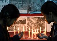 Dos estudiantes encienden velas para rendir homenaje a las víctimas del terremoto de Turquía, en Amritsar.