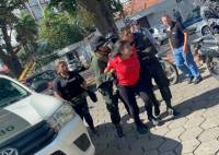 El momento que una de las personas es trasladada por personal policial